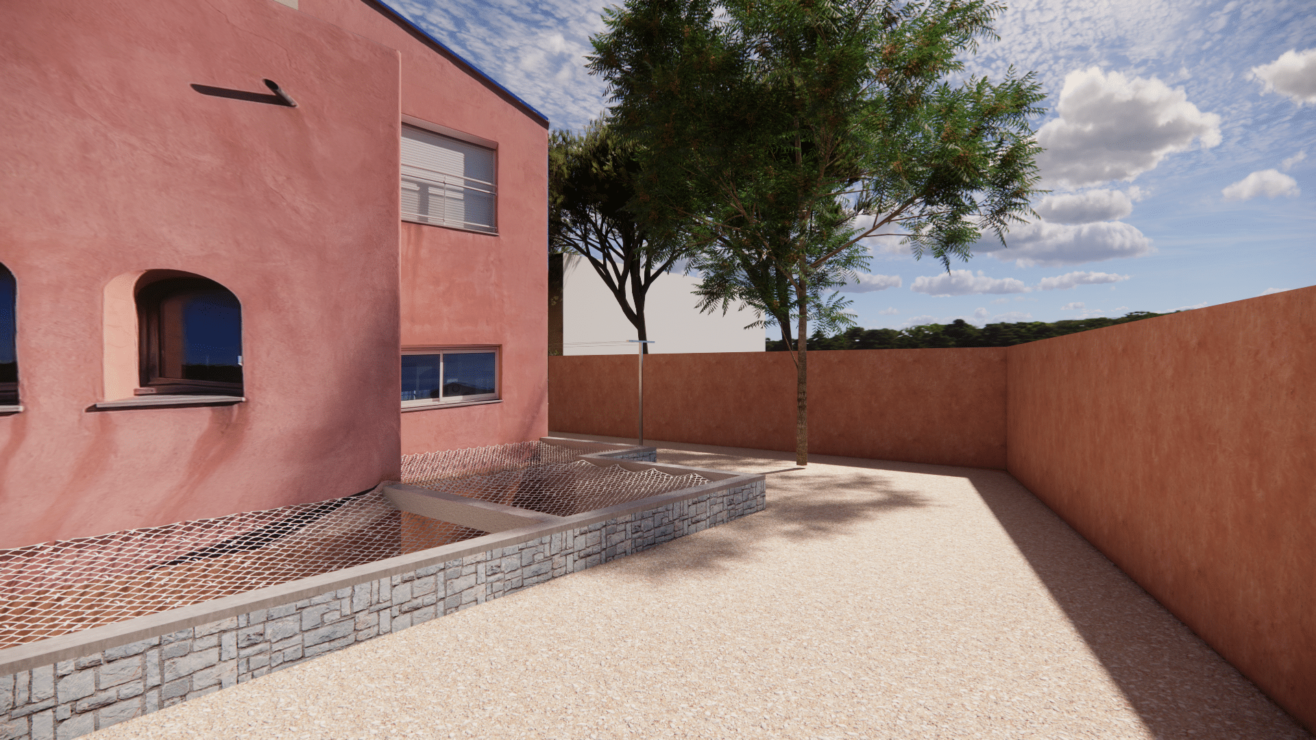 Maison contemporaine rose avec jardin de gravier, filet de protection et mur en pierre sous ciel bleu.