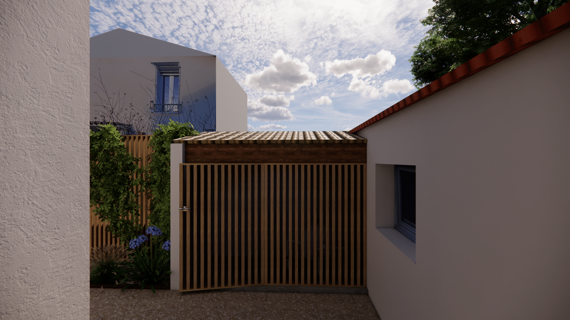 Portail en bois à lattes, mur blanc et toit en tuiles dans une cour ensoleillée avec fleurs bleues.