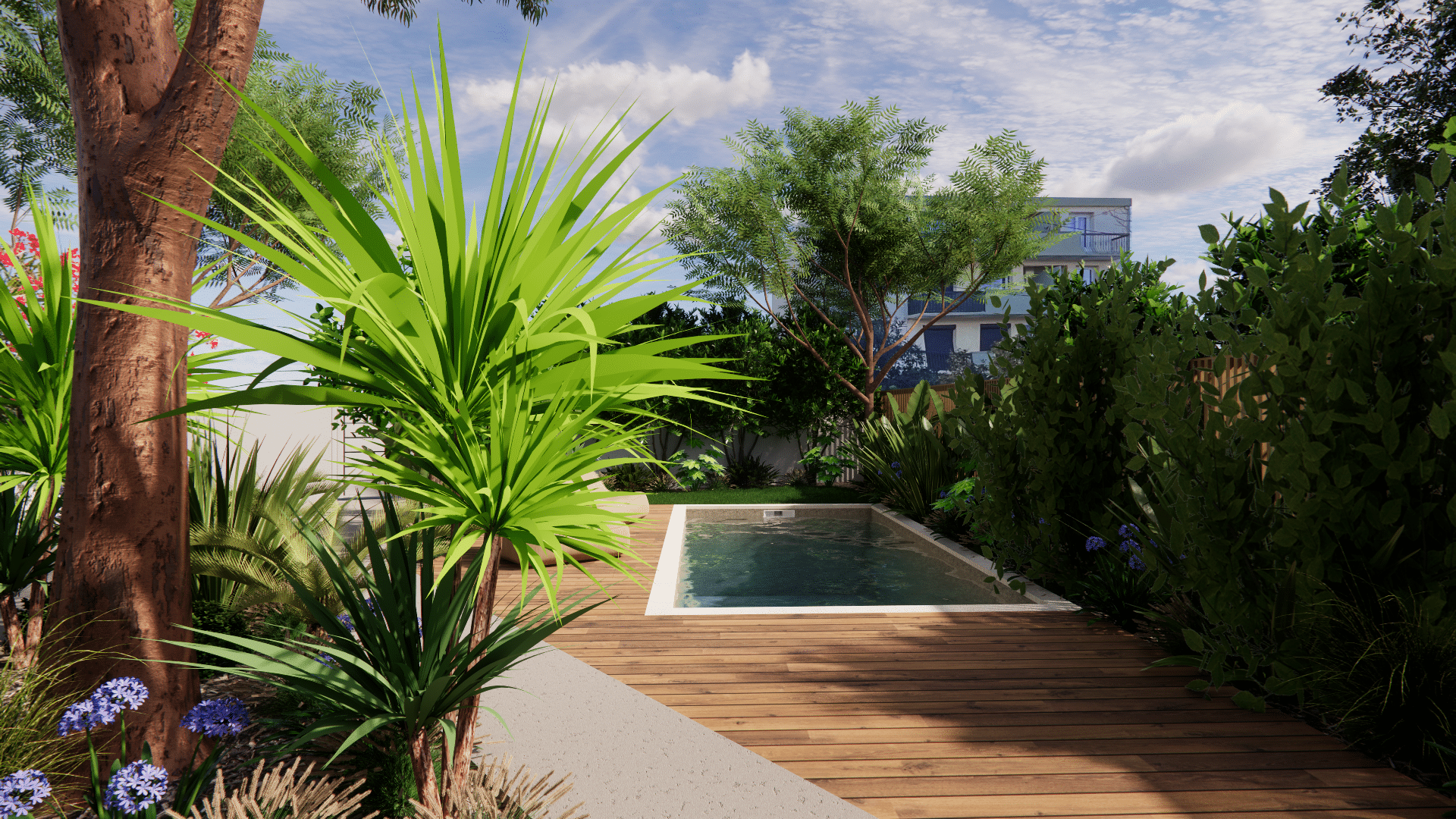 Piscine de jardin avec terrasse en bois entourée de plantes tropicales et d'arbres sous un ciel bleu ensoleillé.