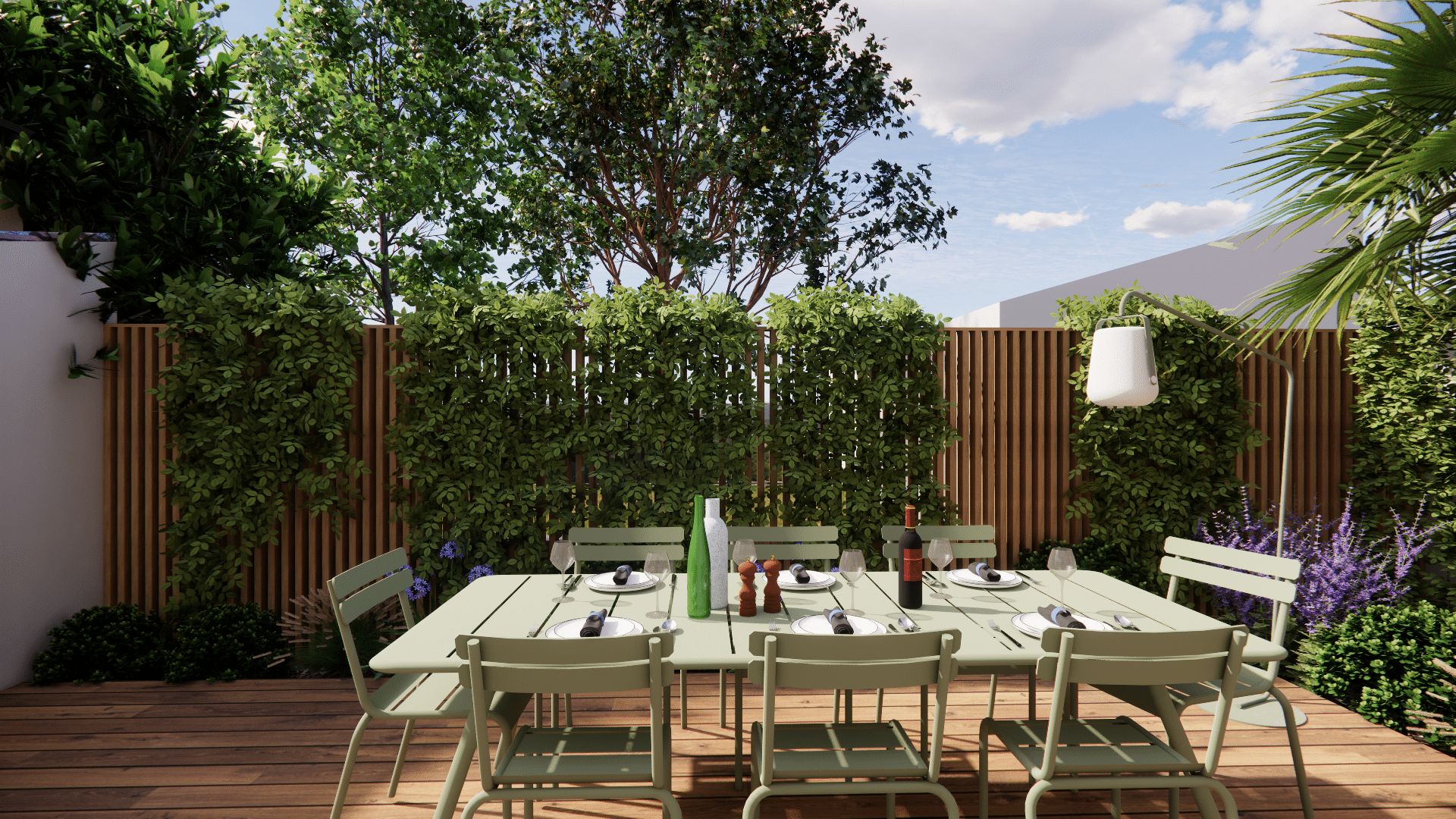 Table à manger extérieure vert sauge sur terrasse en bois avec chaises design et mur de plantes grimpantes.