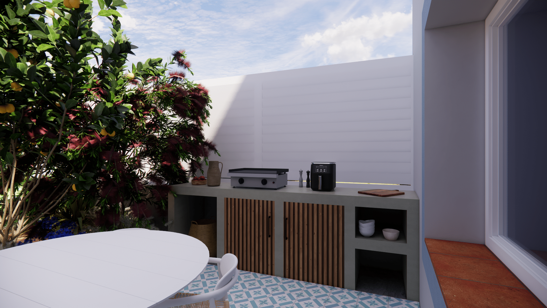 Cuisine d'été moderne en béton, table blanche et citronnier sur terrasse carrelée.